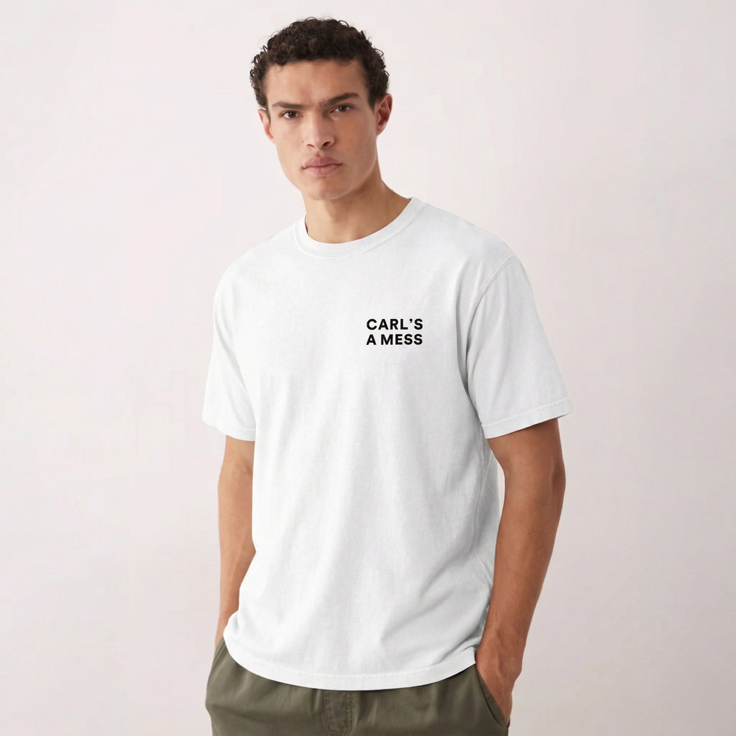 Man wearing a white t-shirt with 'CARL'S A MESS' text on a plain background