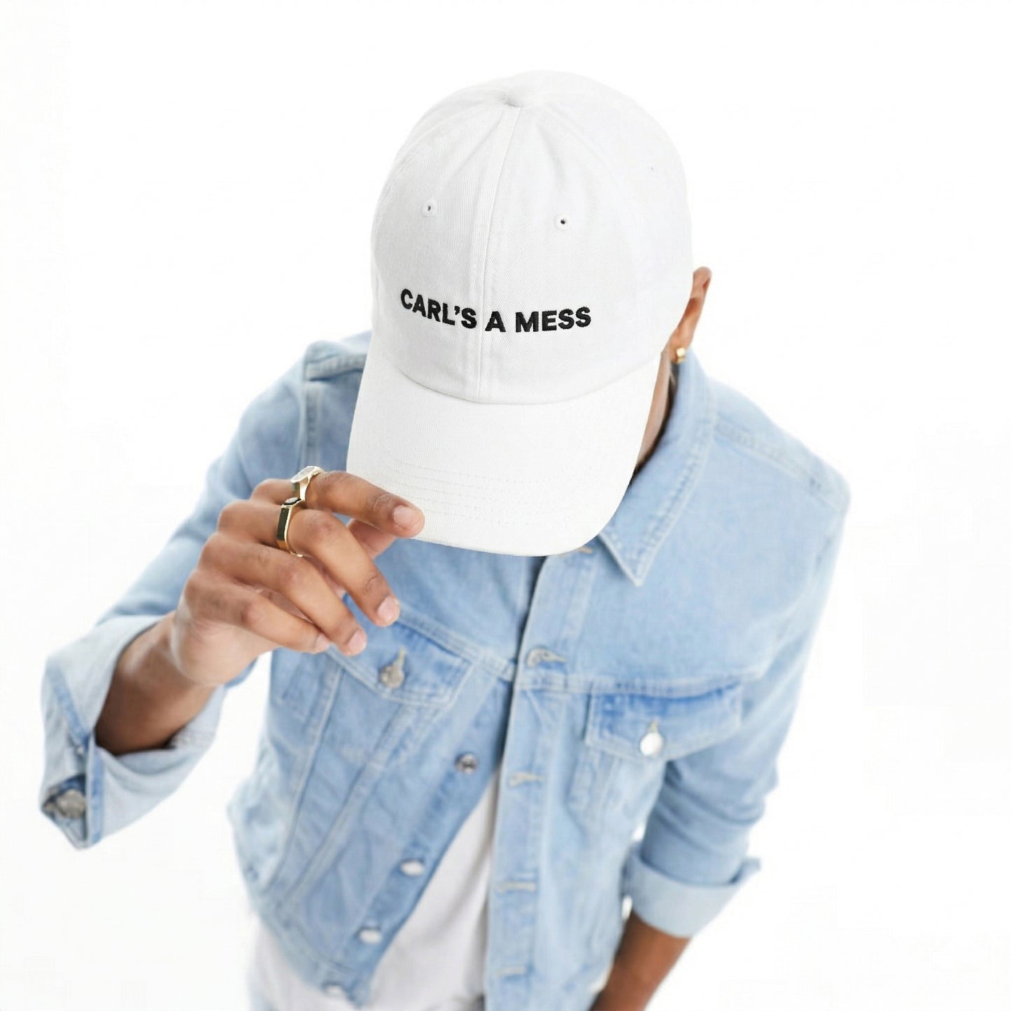 Person wearing a white cap with 'CARL'S A MESS' text, light blue denim jacket on a white background