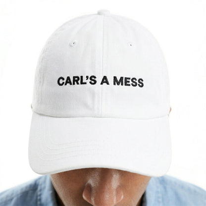 White cap with 'CARL'S A MESS' text worn by a person on a white background