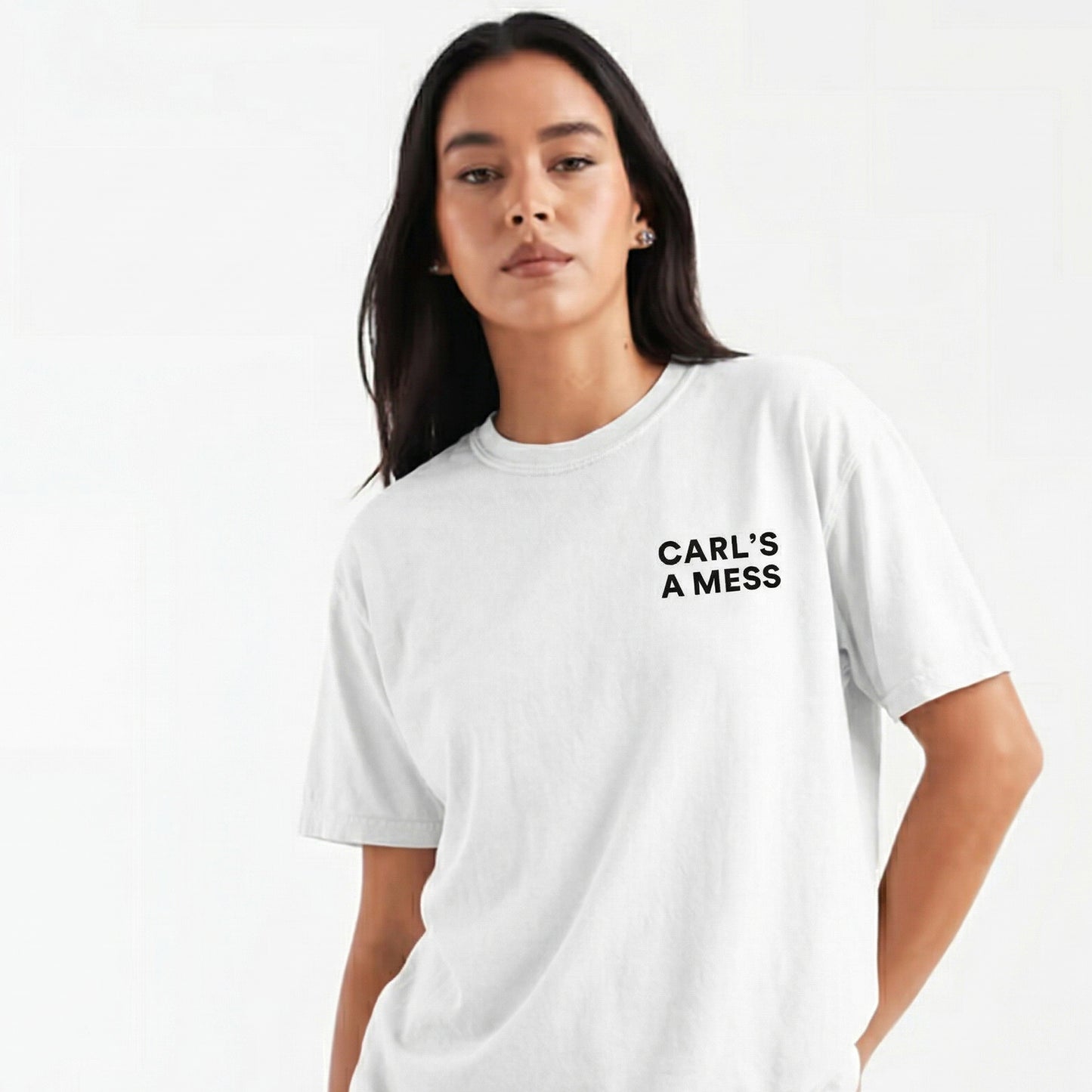 Person wearing a white t-shirt with 'CARL'S A MESS' text on a plain background