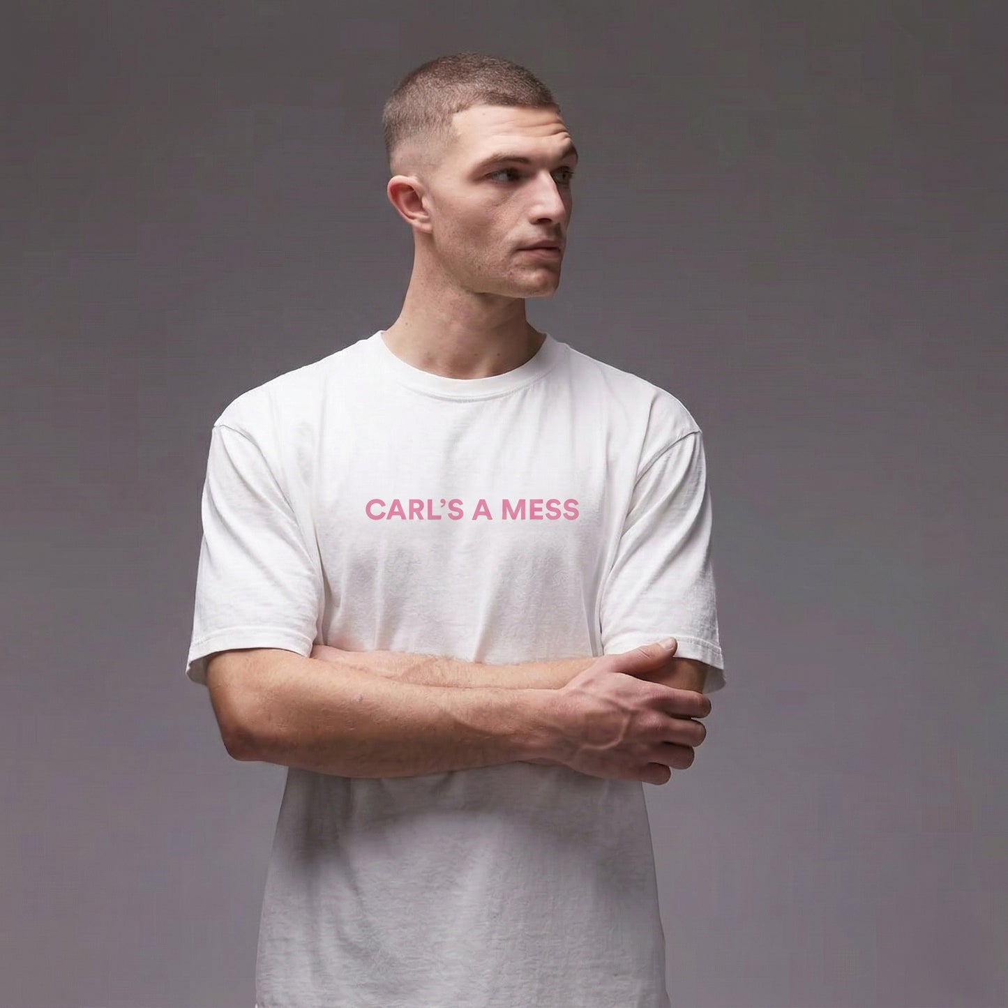 Man wearing a white t-shirt with 'CARL'S A MESS' text on a gray background